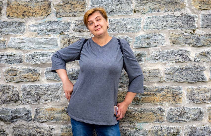 Middle aged woman standing by the wall
