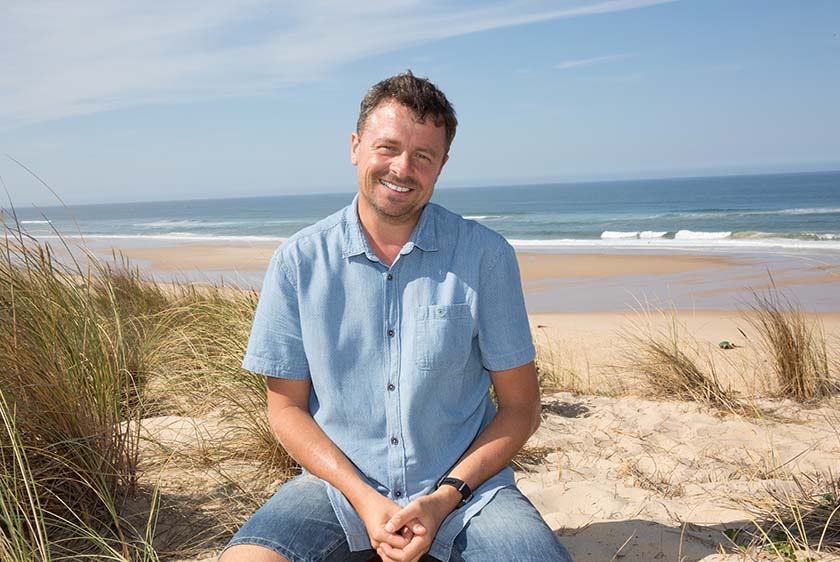 Man in blue shirt in front of the sea