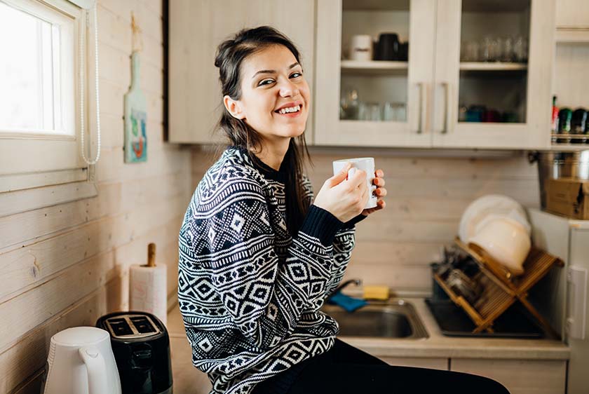 Smiling woman in sweater holding a cup