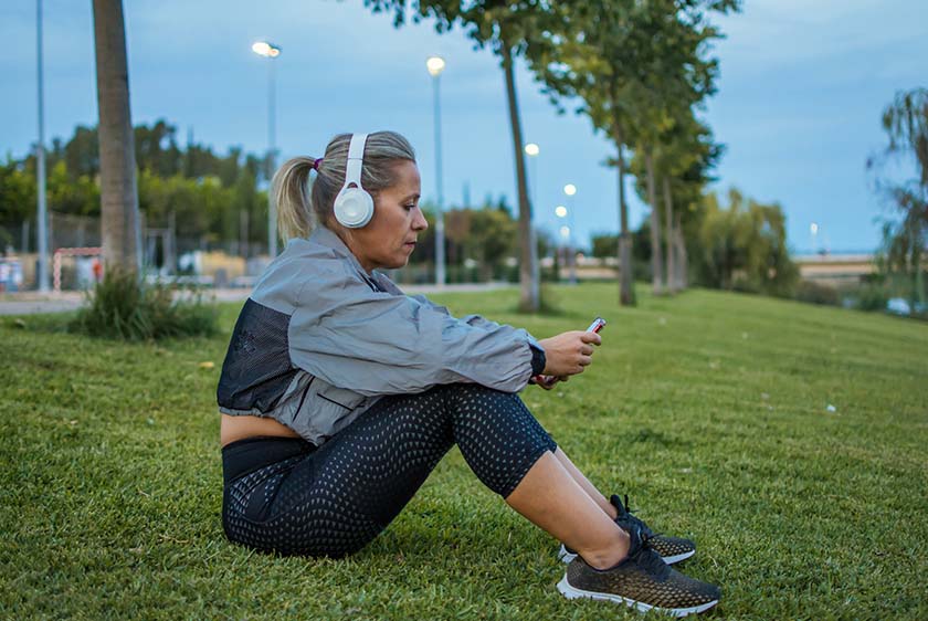 Woman in jogging pants wearing headphones