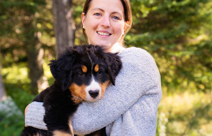 Brown haired woman holding a dog