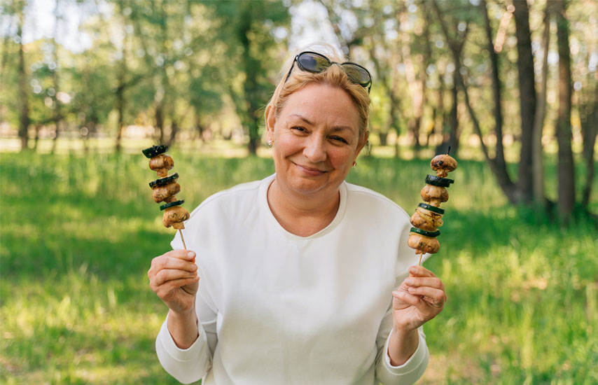 Middle aged woman holding food on a sticks