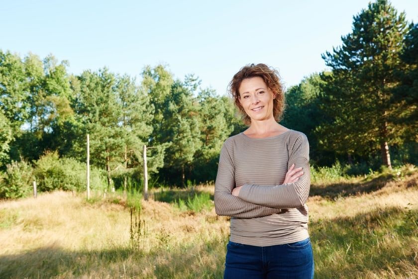 Middle aged woman posing in woods
