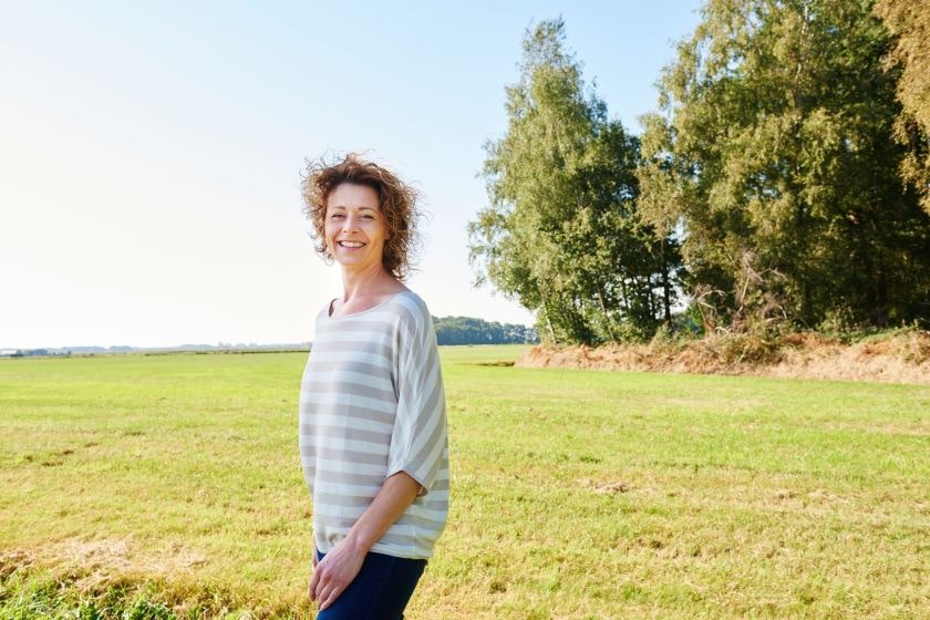 Smiling middle aged woman posing in field