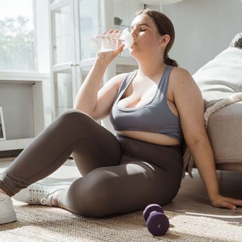 Woman in sport outfit drinking a water
