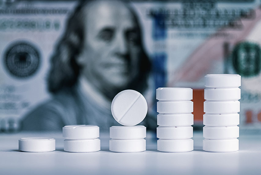 pills stacked against dollar bill background