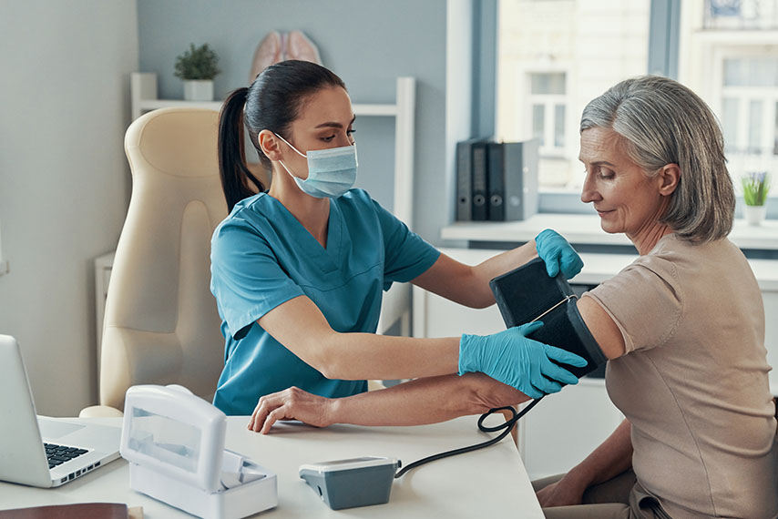 young woman checking blood pressure of an mature woman