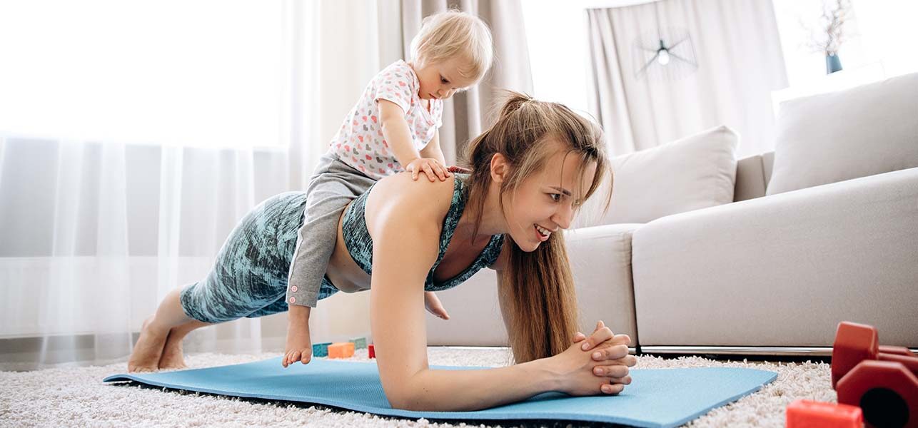 Woman in plank position with baby on her back