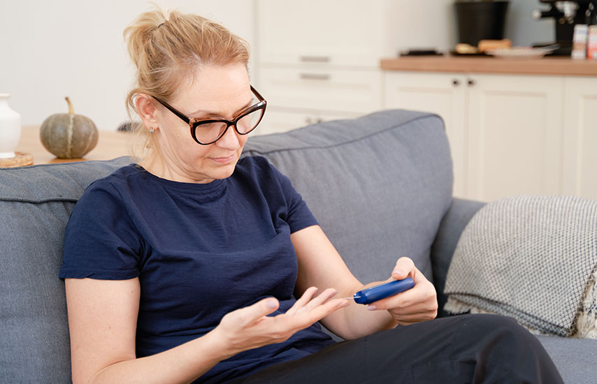 Woman in dark t-shirt using glucose monitor