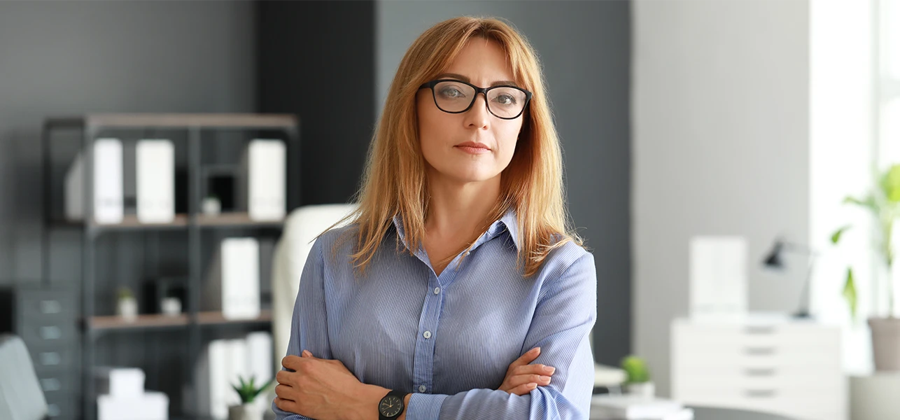 woman with glasses standing arms crossed